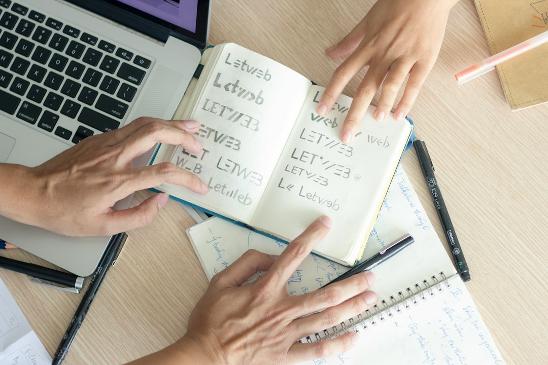 Libro abierto junto a una computadora portátil en un espacio de estudio